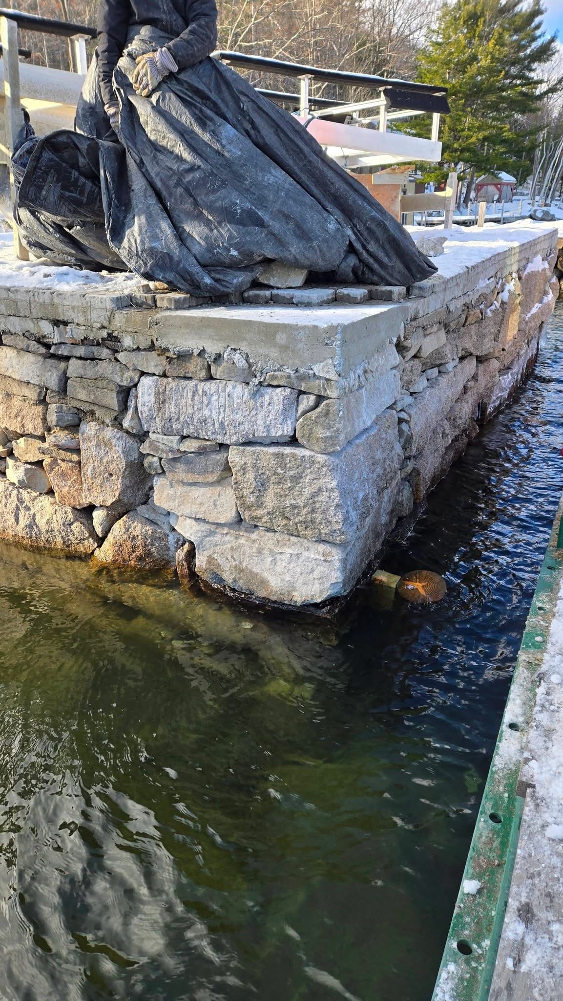 Newly built granite block retaining wall in winter, vertical