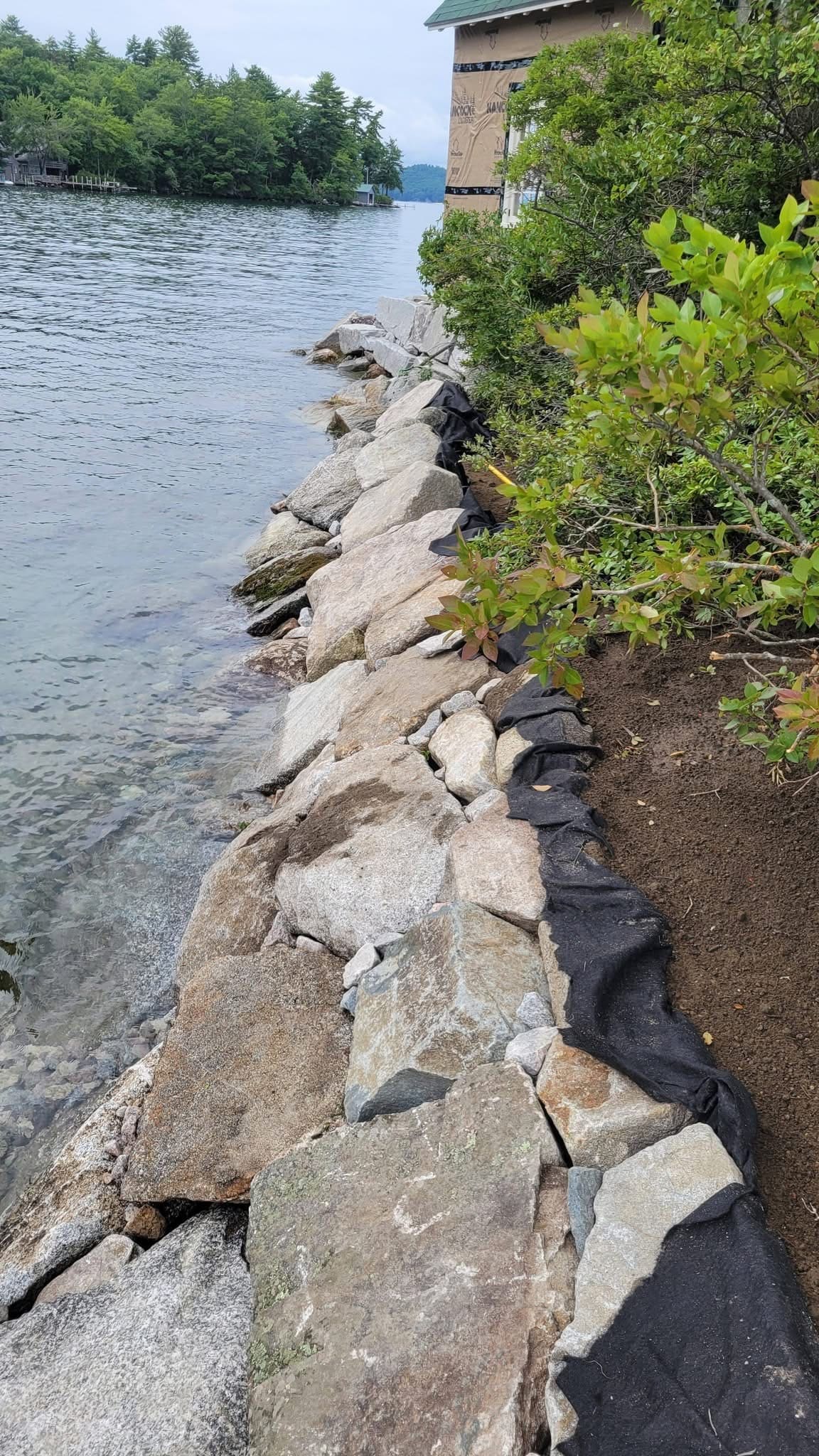 Boulder rip-rap installation with geotextile visible, vertical craft detail