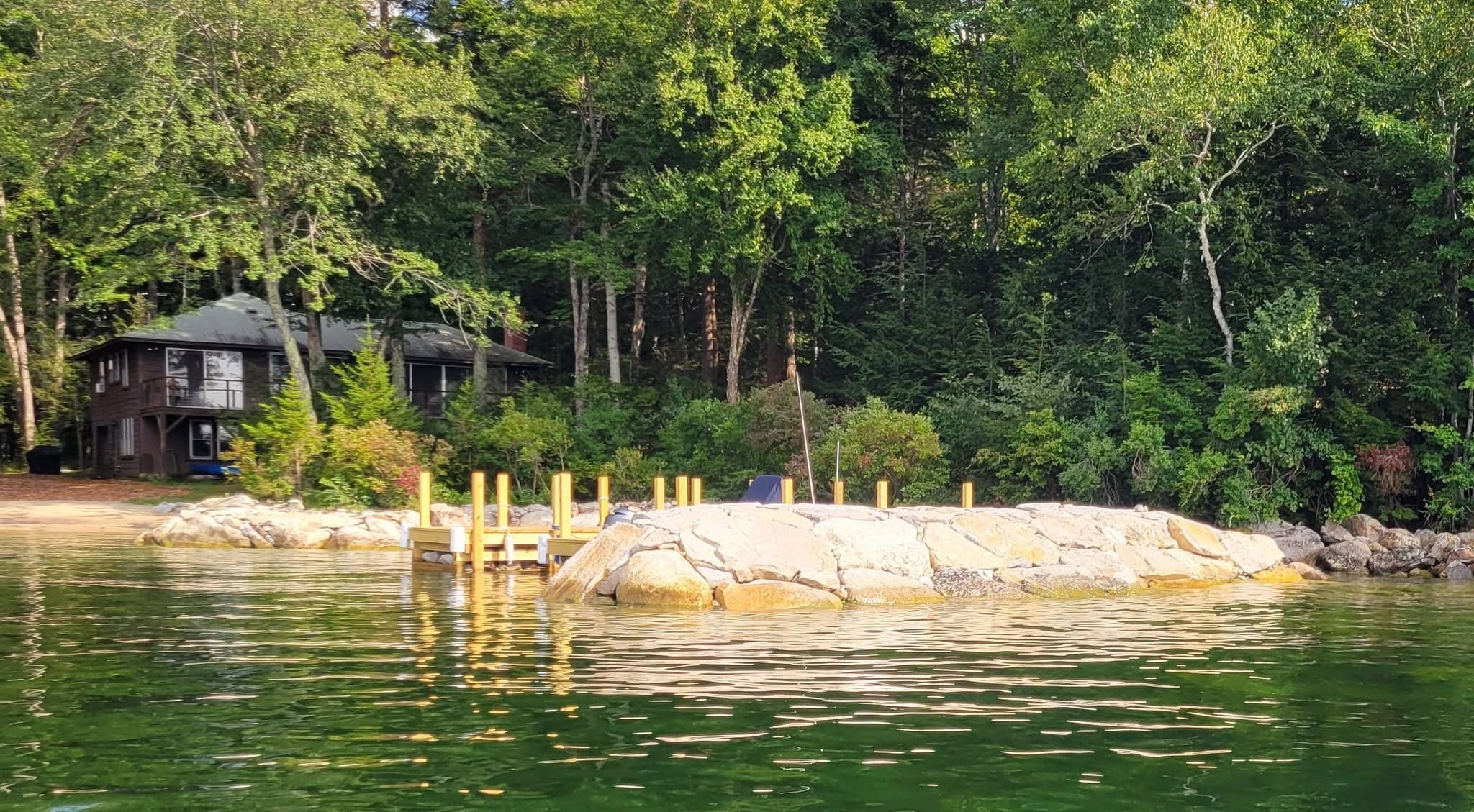 Completed shoreline reinforcement viewed from the water in summer