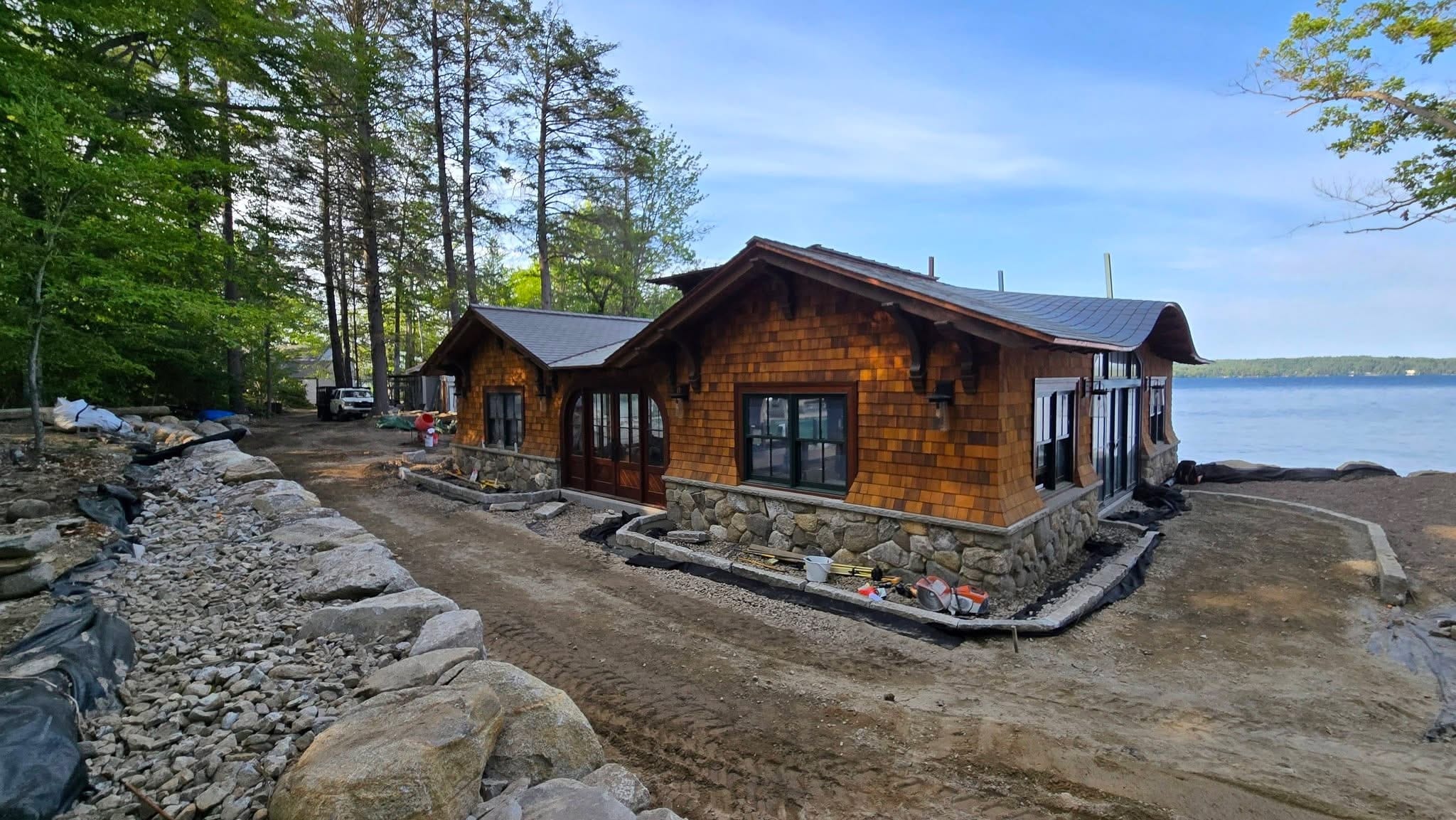 Cedar shake cabin with new stonework retainer wall meeting the lake edge