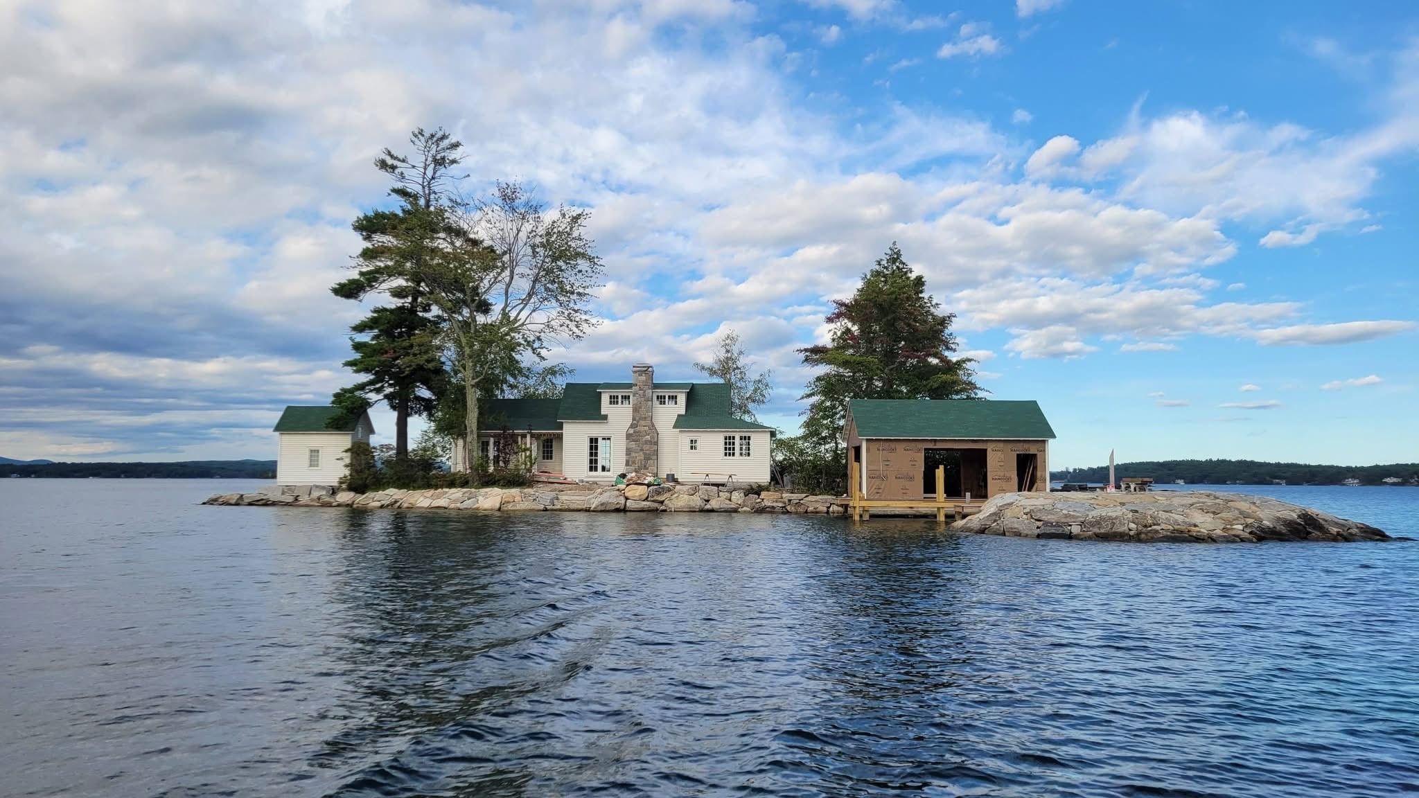 Lake island home with cedar boathouse and completed stonework on Long Island